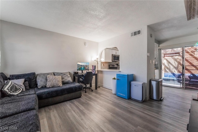 living room with a textured ceiling and hardwood / wood-style flooring