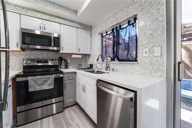 kitchen with stainless steel appliances, white cabinetry, plenty of natural light, and sink