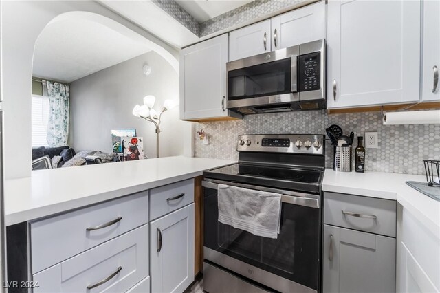 kitchen featuring white cabinets, appliances with stainless steel finishes, and backsplash