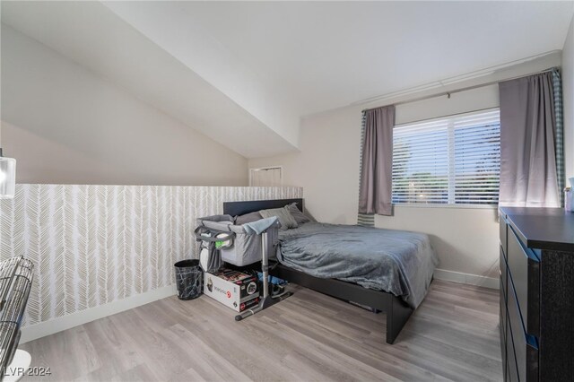 bedroom featuring wood-type flooring and vaulted ceiling