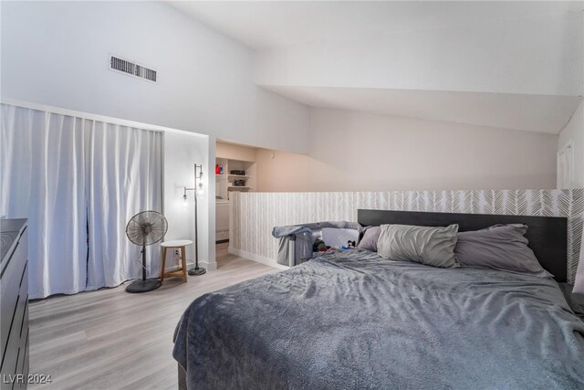 bedroom with light hardwood / wood-style floors and vaulted ceiling