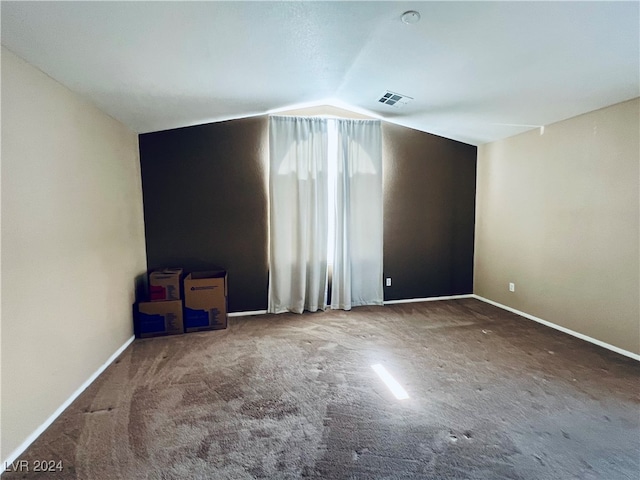 empty room with vaulted ceiling and carpet