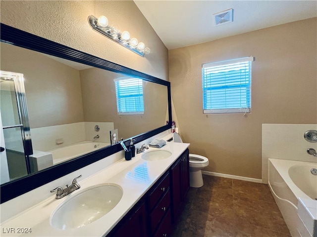 bathroom with vanity, lofted ceiling, a washtub, and toilet