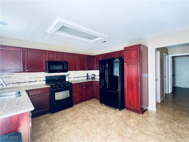 kitchen with a textured ceiling, black appliances, backsplash, and sink