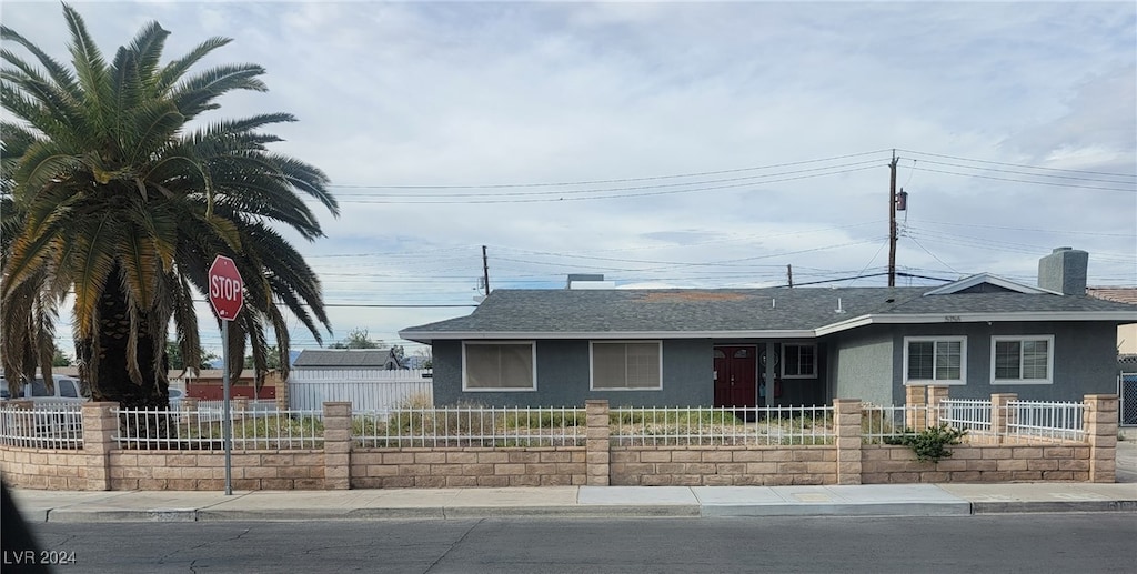 5156 Treasure Ave, Las Vegas, NV 89122 - view of front of property with stucco siding, roof with shingles, a fenced front yard, and a chimney