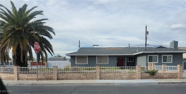 5156 Treasure Ave, Las Vegas, NV 89122 - view of front of property with stucco siding, roof with shingles, a fenced front yard, and a chimney