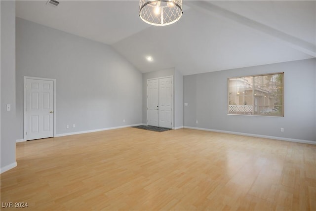 interior space featuring light hardwood / wood-style floors, lofted ceiling, and a notable chandelier