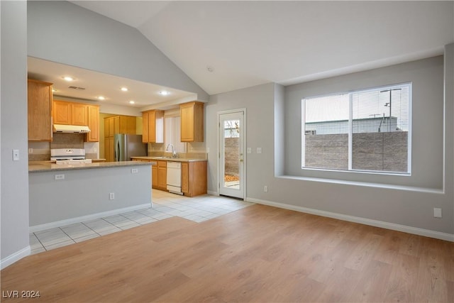 kitchen with light hardwood / wood-style flooring, kitchen peninsula, lofted ceiling, white appliances, and light brown cabinetry