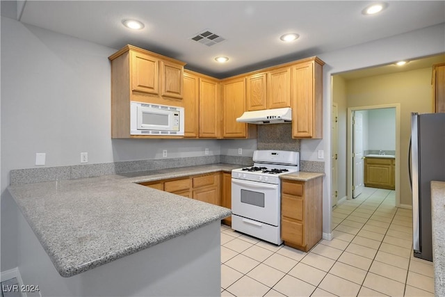 kitchen featuring kitchen peninsula, light brown cabinetry, white appliances, and light tile patterned floors