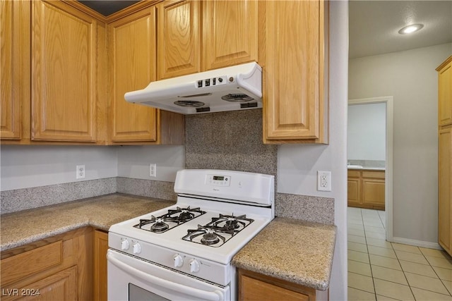 kitchen featuring decorative backsplash, light tile patterned flooring, and white range with gas stovetop