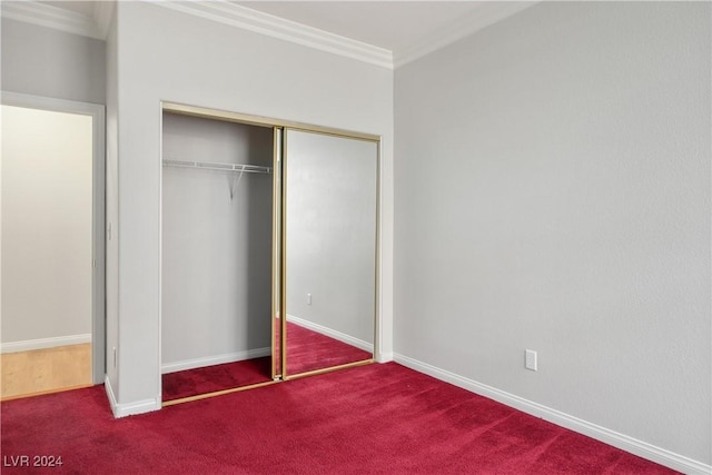 unfurnished bedroom with a closet, carpet, and ornamental molding