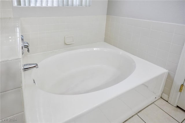 bathroom with tile patterned flooring and a tub