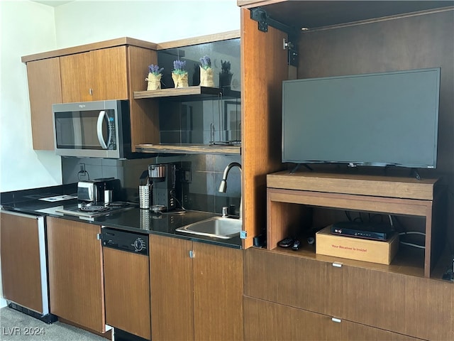 kitchen featuring sink, dishwashing machine, and tasteful backsplash