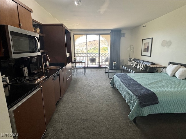 bedroom featuring dark carpet, access to outside, and sink