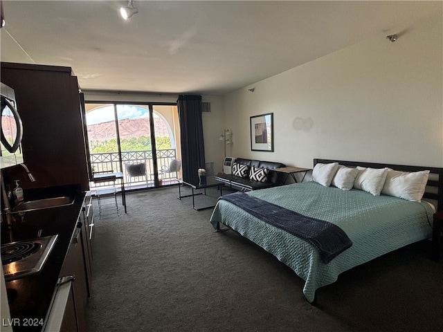 carpeted bedroom with sink and access to exterior