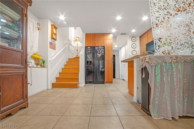 kitchen featuring light tile patterned floors, kitchen peninsula, and black appliances