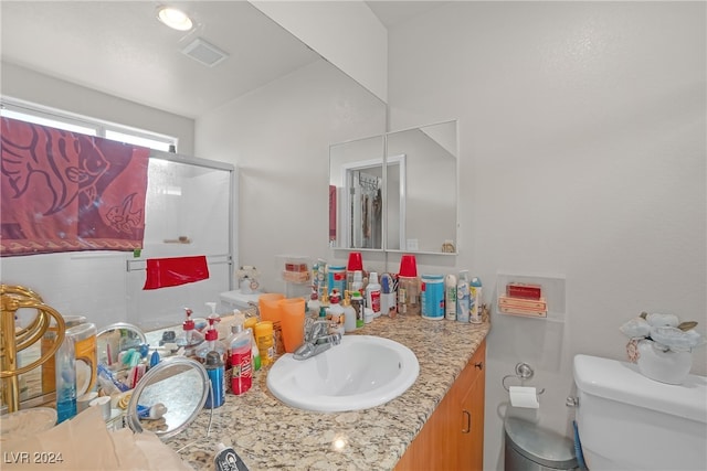 bathroom with vanity, toilet, and an enclosed shower