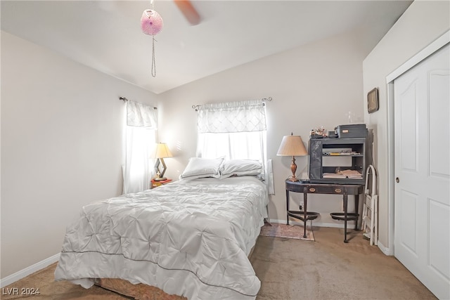 carpeted bedroom featuring a closet, lofted ceiling, and ceiling fan