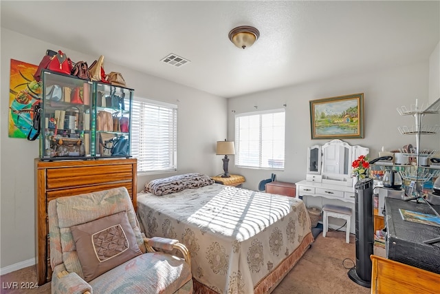 bedroom featuring light carpet and multiple windows