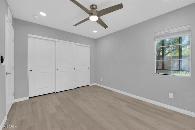 unfurnished bedroom featuring light hardwood / wood-style flooring, a closet, and ceiling fan