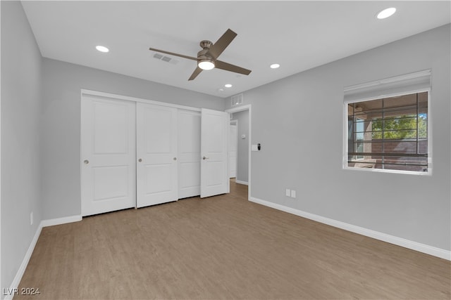 unfurnished bedroom featuring light hardwood / wood-style flooring, a closet, and ceiling fan