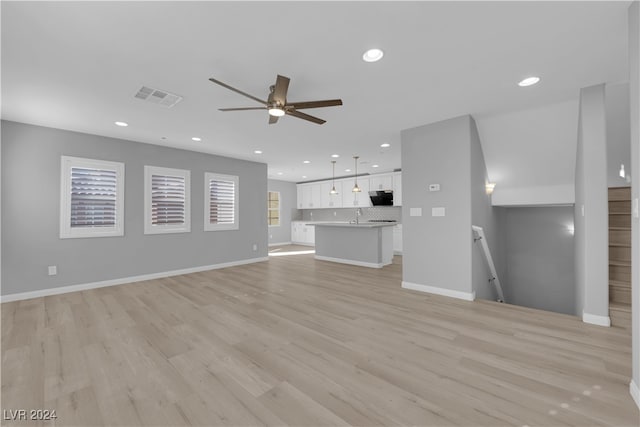 unfurnished living room with light hardwood / wood-style flooring, ceiling fan, and sink