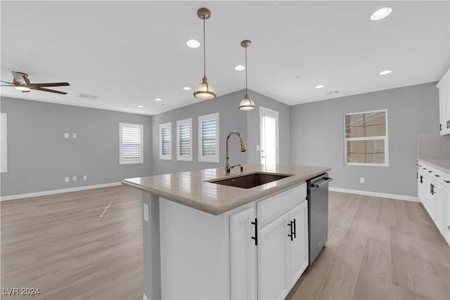 kitchen featuring white cabinets, a kitchen island with sink, sink, and stainless steel dishwasher