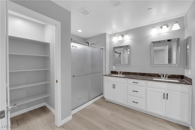 bathroom featuring walk in shower, vanity, and hardwood / wood-style floors