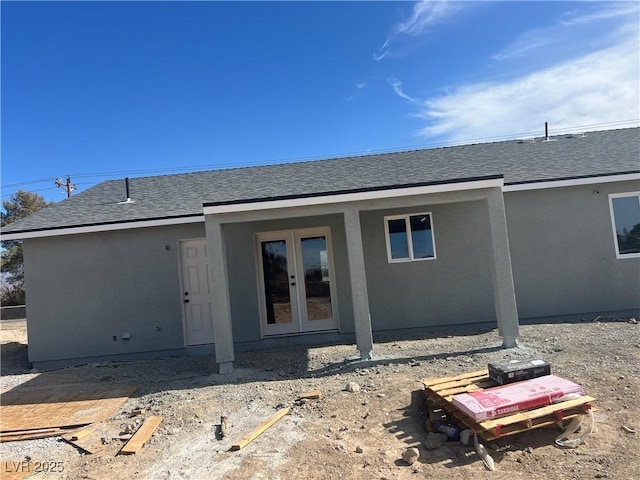 back of house featuring a shingled roof, french doors, and stucco siding