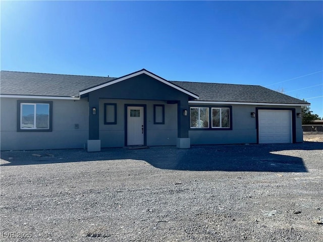 single story home with an attached garage, roof with shingles, and stucco siding