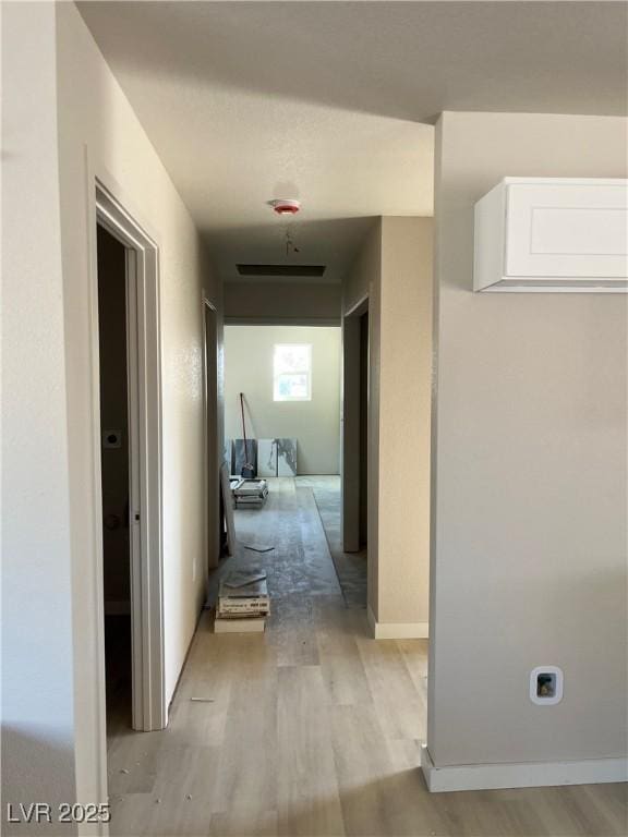 hall with light wood finished floors and baseboards