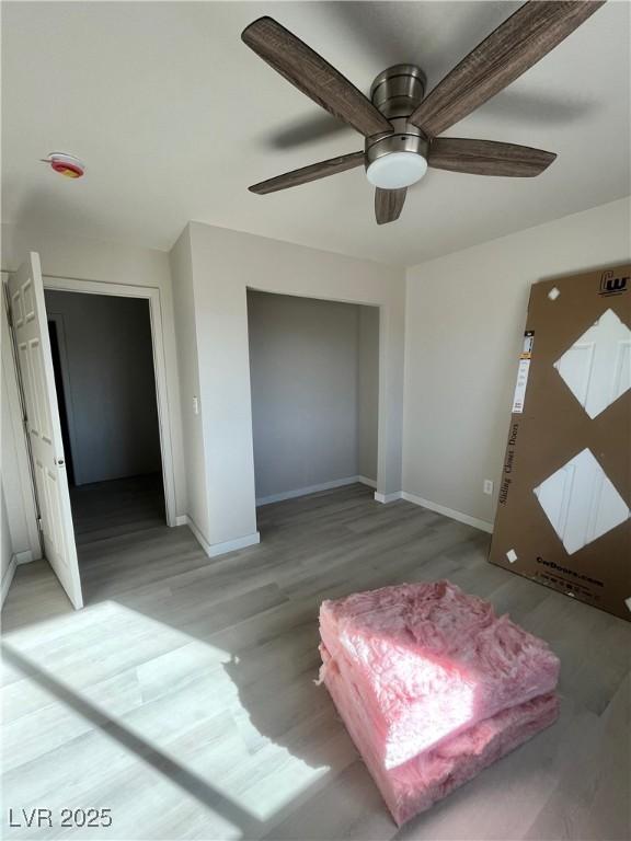 interior space with ceiling fan, light wood-style flooring, and baseboards