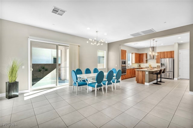 dining room with a notable chandelier, light tile patterned floors, and sink