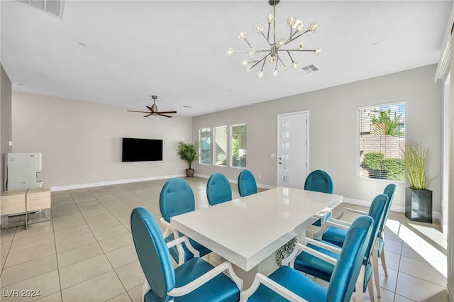 dining space with light tile patterned floors, a healthy amount of sunlight, and ceiling fan with notable chandelier