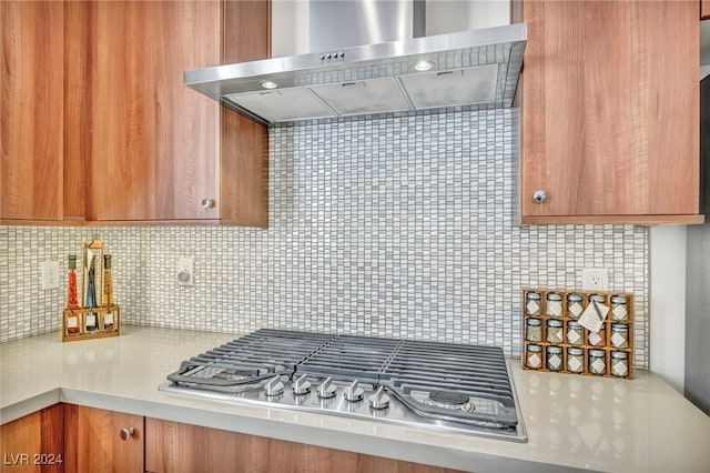 kitchen with stainless steel gas cooktop, decorative backsplash, and wall chimney exhaust hood