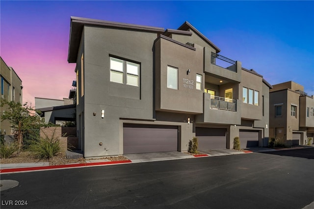 view of front of property featuring a balcony and a garage