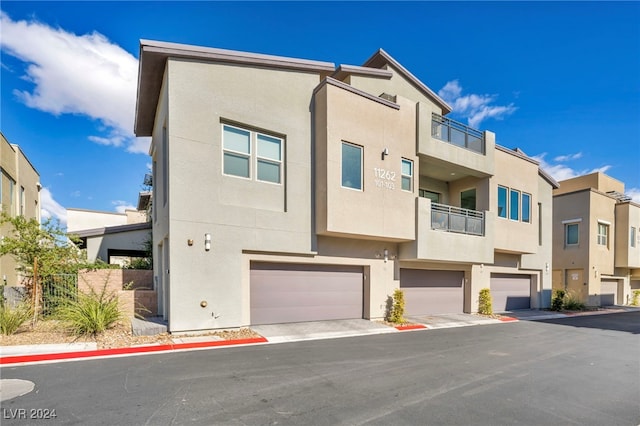 multi unit property featuring a garage and a balcony