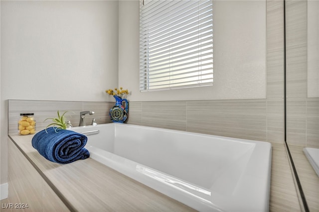 bathroom featuring tile walls and a bath