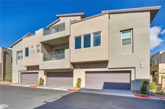 view of property featuring a garage and a balcony