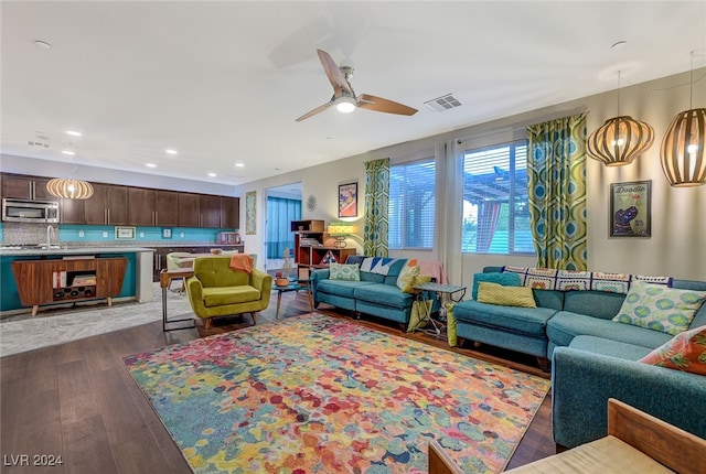 living room featuring dark hardwood / wood-style floors, ceiling fan, and sink