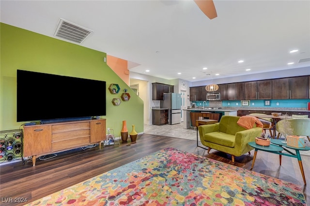 living room featuring ceiling fan, dark hardwood / wood-style flooring, and sink