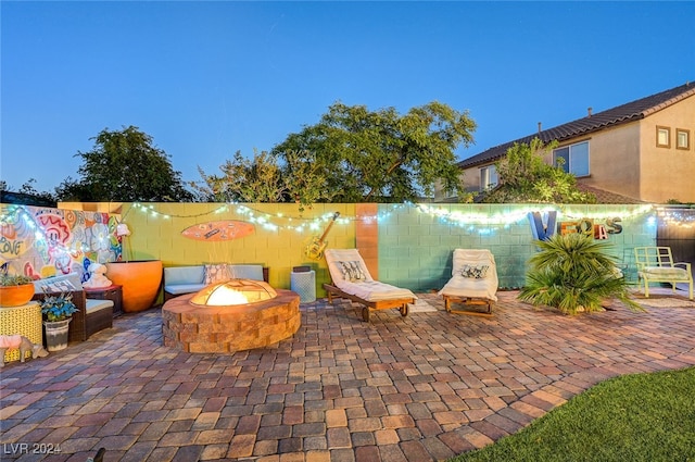 patio terrace at dusk featuring an outdoor fire pit