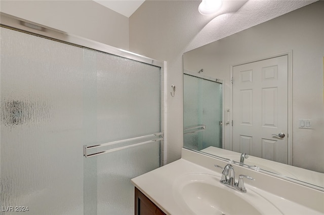 bathroom featuring vanity and a shower with shower door