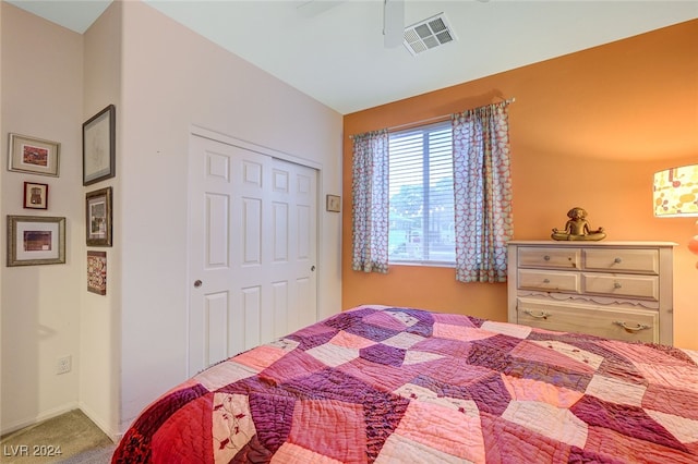 carpeted bedroom with ceiling fan and a closet