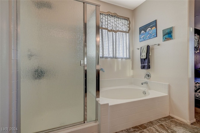 bathroom featuring shower with separate bathtub