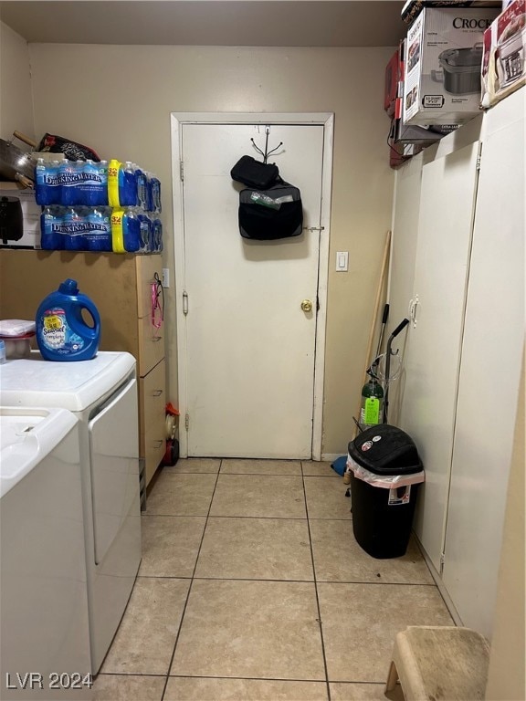 laundry area featuring washing machine and clothes dryer and light tile patterned floors