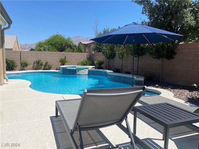 view of swimming pool featuring an in ground hot tub, a mountain view, and a patio area