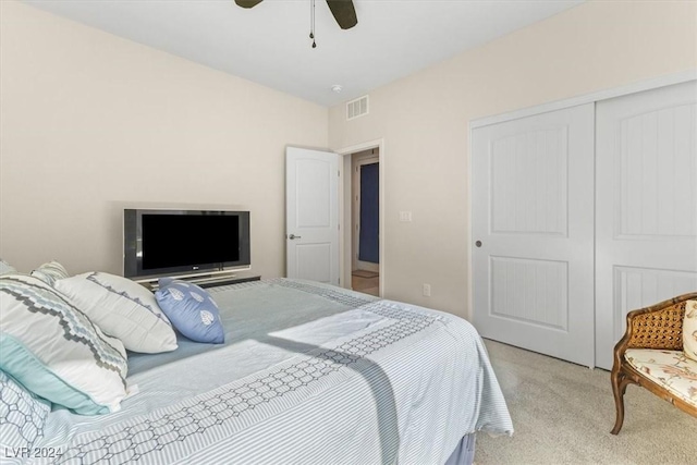 bedroom featuring light colored carpet, a closet, and ceiling fan