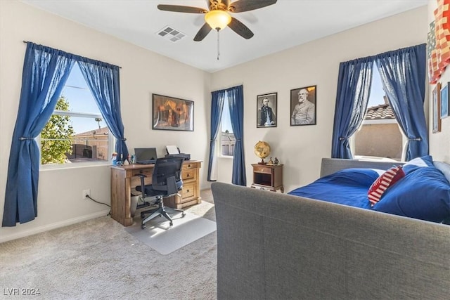 carpeted office space featuring ceiling fan