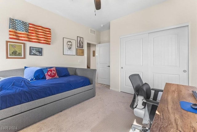 bedroom with light colored carpet, a closet, and ceiling fan